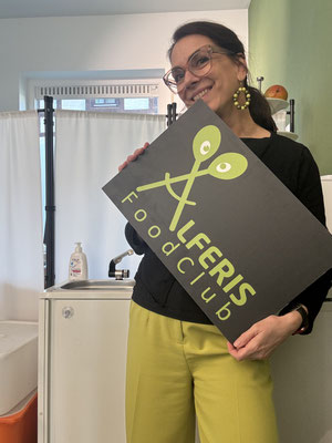 Alferis Balancebistro Besitzerin hält einem Schild mit dem Logo